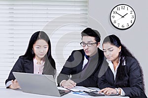 Business partners discussing with laptop