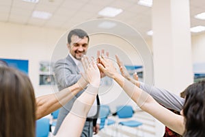 Business partners giving each other a high five on a blurred background. Office unity concept.