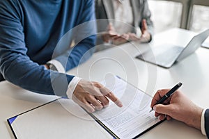 Business partners sealing successful deal with signing contract at office desk