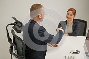 Business partners shake hands while concluding a deal. Deaf business man.