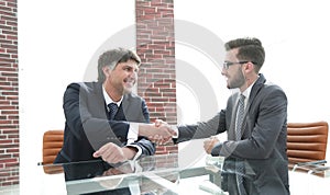 Business partners shake hands after discussing the contract