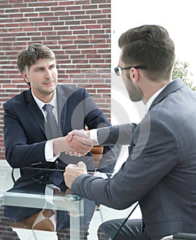 Business partners shake hands after discussing the contract