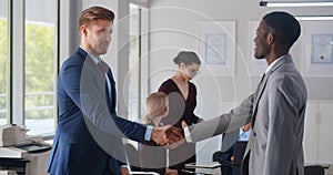 Business partners shaking hands in modern workplace office