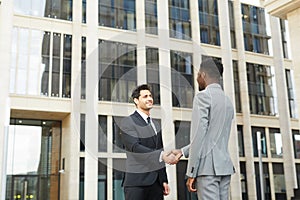 Business partners shaking hands outdoors