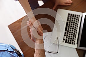 Business partners shaking hands over table after meeting