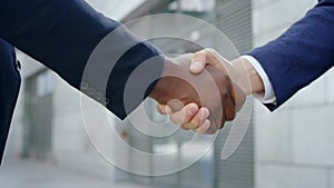 Business partners shaking hands on street. Handshake of businessmen outdoors