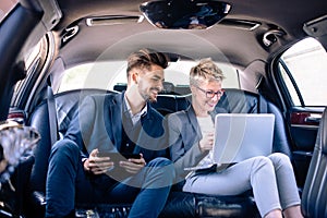 Business partners smiling in limo