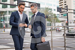 Business partners talking outdoor. Two businessmen discussing outdoor. Two business people talk project strategy. Two