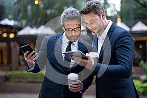 Business partners using tablet on coffee break, meeting outdoor. Business partners talk conversation outdoor. Two