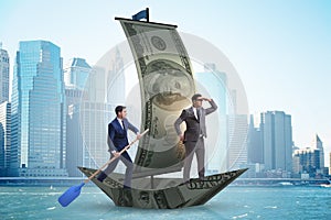 The business partnership with businessmen sailing on dollar boat