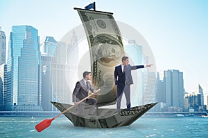 The business partnership with businessmen sailing on dollar boat