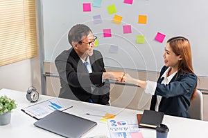 Business partnership concept, Business senior making fist bump with partner after successful work