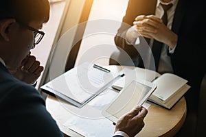 Business partnership coworkers using a tablet to chart company financial statements report and profits work progress and planning