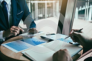 Business partnership coworkers using a tablet to chart company financial statements report and profits work progress and planning