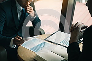 Business partnership coworkers using a tablet to chart company financial statements report and profits work progress and planning