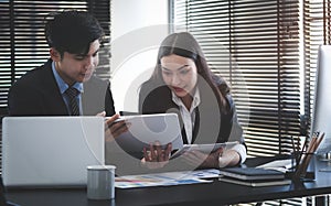 Business people analysing and discussing online data with laptop computer in office