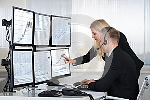 Business People Analyzing Data Displayed On Computer Screens