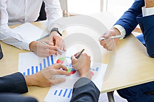 Business People Analyzing Financial Results on Graphs around the Table in Modern Office. Team Work Concept