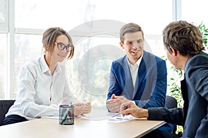 Business People Analyzing Financial Results on Graphs around the Table in Modern Office. Team Work Concept