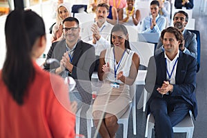 Business people applauding female speaker in business seminar