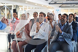 Business people applauding male speaker in business seminar