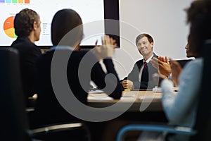 Business People Applauding Manager Doing Presentation In Meeting