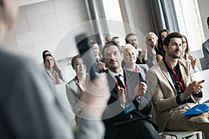Business people applauding for public speaker during seminar