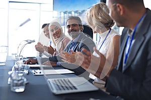 Business people applauding at table in conference room