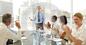 Business people applauding their colleague after presentation