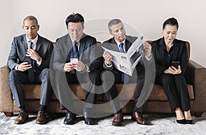 Business people busy with mobile and reading newspaper
