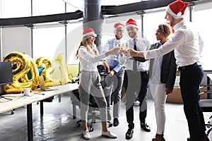 Business people are celebrating holiday in modern office drinking champagne and having fun in coworking