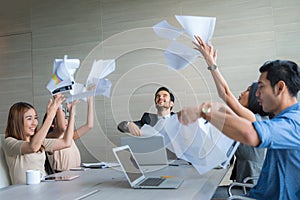 Business people celebrating by throwing documents after working