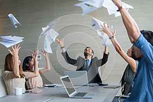 Business people celebrating by throwing documents after working