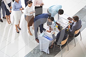 Business people checking in at conference registration table