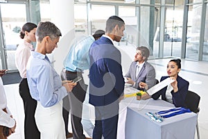 Business people checking in at conference registration table