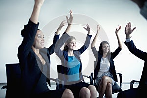 Business people cheering with arms in the air