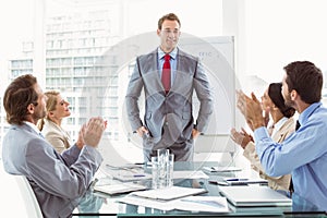 Business people clapping hands in board room meeting