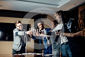 Business people clinking glasses and smiling while celebrating in meeting