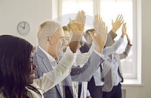 Business people at the conference raising hands voting in the office.