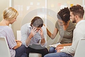 Business people consoling businessman suffering from headache