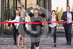 Business people crossing red finish line