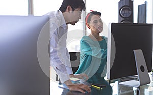 Business people discussing over computer at desk in office