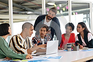 Business people discussing over laptop in the conference room