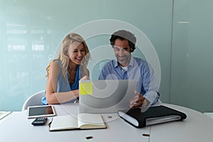 Business people discussing over laptop at desk in a modern office