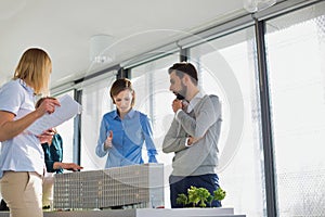 Business people discussing over new building structure plan in office