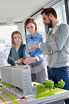 Business people discussing over new building structure plan in office