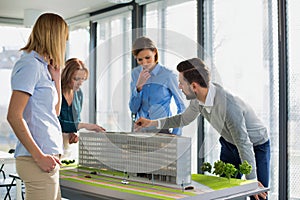 Business people discussing over new building structure plan in office