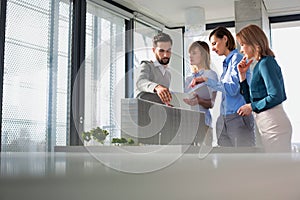 Business people discussing over new building structure plan in office