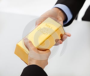 Business people exchanging golden bar