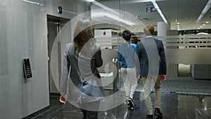 Business people exiting lift car in corridor. Businessman hurry for meeting